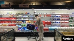 A shopper pushes a cart inside a supermarket on February 11 following an outbreak of the new coronavirus in the Chinese city of Wuhan in Hubei Province.