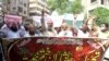 A banner reads in Arabic, 'I will sacrifice my parents for the Prophet's honor' at a protest to support the man who killed a man accused of blasphemy inside a court, in Hyderabad, on July 30.