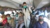 A volunteer sprays disinfectant on passengers traveling to their villages to celebrate the upcoming Eid al-Fitr holiday that marks the end of the Muslim holy fasting month of Ramadan on May 22.