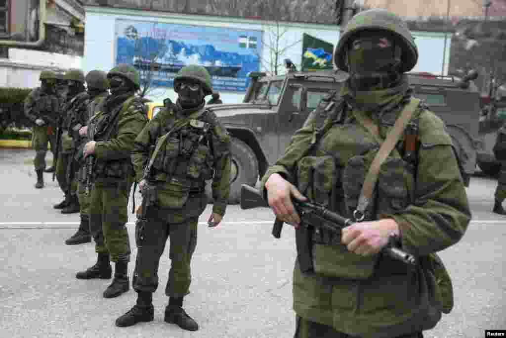 Ukrayna, Balaslava şəhəri. 1 mart 2014. Rusiya ordusuna məxsus hərbi maşının üstündə dayanan əsgərin geyimində hansı ölkənin ordusuna qulluq etdiyinə dair məlumat yoxdur. 