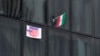 پرچم جمهوری اسلامی و یک پوستر ضد آمریکایی روی پنجرۀ یک ساختمان دولتی در مقابل سفارت سابق آمریکا در تهران، ۱۳ آبان ۱۴۰۲