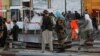 Taliban fighters stand guard at the site of the blast in Kabul on August 6. 