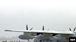 U.S. military servicemen board a plane at the military air base in Manas.