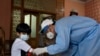 A health worker takes blood sample of a boy during door-to-door testing and screening for the coronavirus in the capital, Islamabad on June 10.