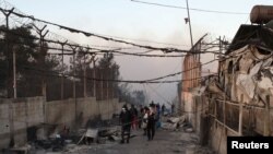 A migrant walks among destroyed shelters following a fire at the Moria migrant camp on the island of Lesbos on September 9. 