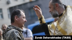 Священик благословляє російського полковника Ігоря Гіркіна (Стрєлкова), який на той час був одним із ватажків незаконного збройного угруповання «ДНР» (визнане в Україні терористичним). Окупований Донецьк, 10 липня 2014 року