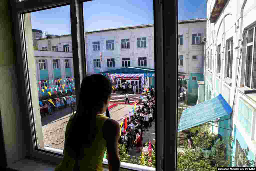 Дівчина спостерігає за святкуванням на честь закінчення школи 25 травня. Бішкек, Киргизстан. (Бексултан Абібакір, Радіо Свобода/Радіо Вільна Європа) 