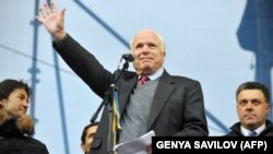 UKRAINE – US Senator John McCain waves to protestors during a mass rally of the opposition Independence Square in Kyiv on December 15, 2013