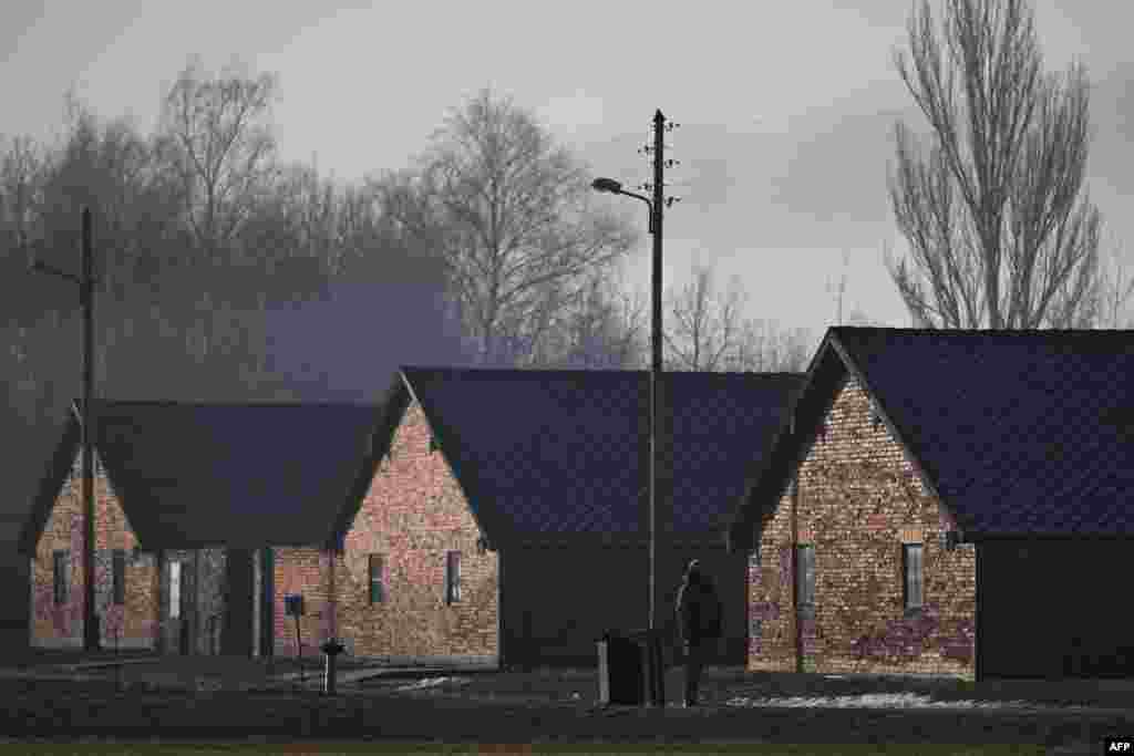 Un ofițer de securitate stă lângă baraca din fostul lagăr de concentrare și exterminare nazist german Auschwitz 2-Birkenau din Oswiecim, Polonia, pe 27 ianuarie 2025, înaintea comemorărilor care marchează cea de-a 80-a comemorare a eliberării lagărului de către Armata Roșie. 