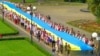 Під час відзначення Дня Державного Прапора України в Ужгороді. Учасники святкування несуть 100-метровий синьо-жовтий стяг, 23 серпня 2016 року