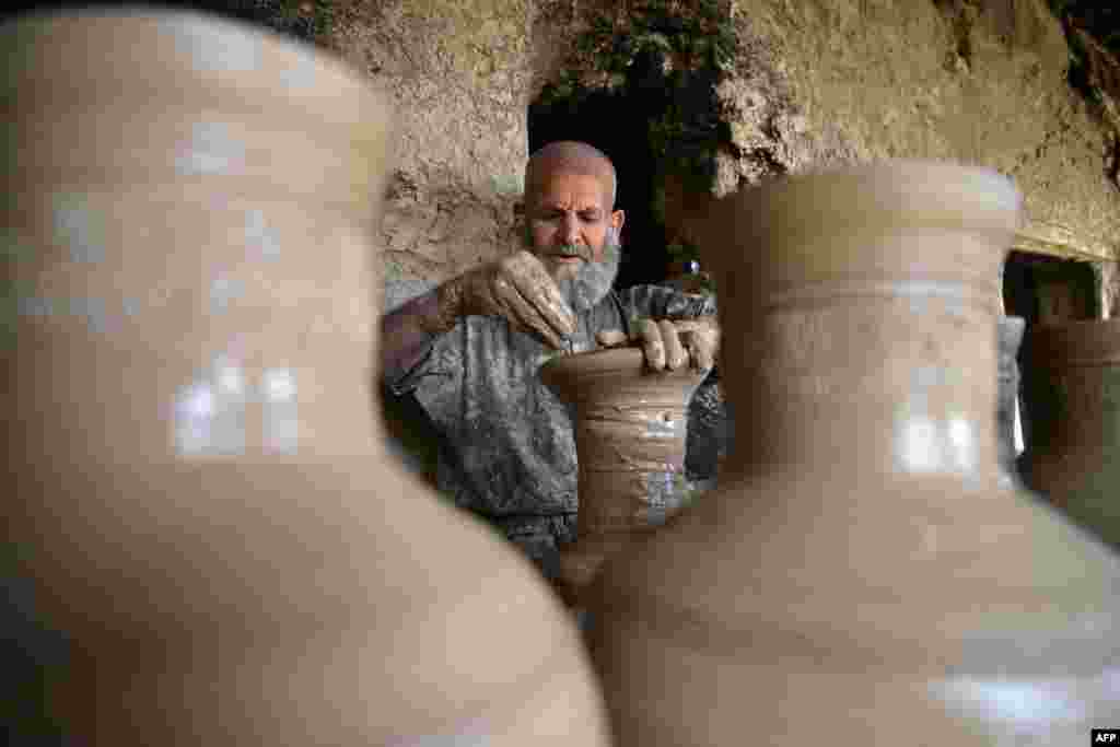 A worker makes a clay pot inside his pottery workshop in Kandahar, Afghanistan.