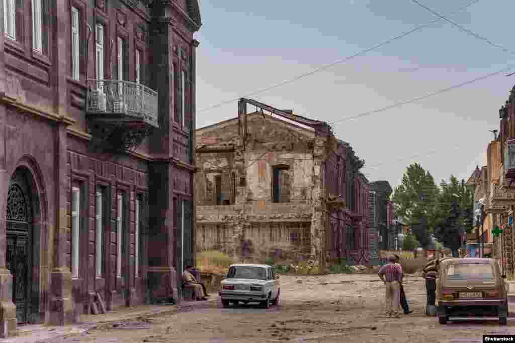 Поврежденные землетрясением здания в Гюмри в 2013 году. В результате толчков была разрушена большая часть городских промышленных предприятий, население сократилось вдвое. Многие местные жители поглядывают на Россию в поисках возможностей заработка. Один из них как-то сказал корреспонденту в 2013 году: "Безработица и бедность страшней перспективы нового землетрясения". 