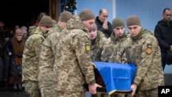 Војници на проштална церемонија во манастирот Св. Михаил го носат ковчегот на украинскиот војник Андриј Кузменко, кој беше убиен во руско-украинската војна (Киев, 10 јануари 2025)