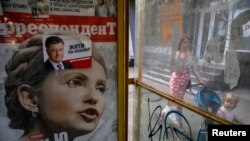 Юлия Тимошенконун жана Петро Порошенконун президенттик шайлоого карата илинген үгүт кагаздары. 