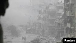 Smoke rises from buildings after what activists said was shelling from government forces in the besieged area of Homs, where the United States called on the government to permit aid to enter.
