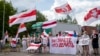 Протестувальники у Литві тримають плакати з написами «Ви знаєте, що робити», «Лукашенко – терорист» та біло-червоно-білі прапори під час акції протесту з вимогою звільнити політичних в’язнів у Білорусі, 8 червня 2021 року