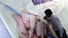A Pakistani journalist signs a banner during a protest against the deteriorating security situation for journalists in the country in May 2018 (file photo).
