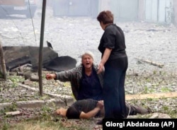 O femeie din Georgia plânge lângă trupul unei victime a războiului Rusiei din Georgia, 9 august 2008.