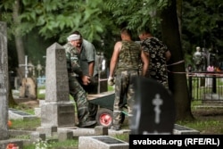 Вайсковыя могілкі ў Менску. Супрацоўнікі Спецкамбіната прыбіраюць надмагілныя пліты.