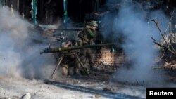 În Bahmut, estul Ucrainei, un militar ucrainean lansează o grenadă anti-tank înspre forțele ruse. În ciuda atacurilor masive, a implicării mercenarilor Wagner și a distrugerii aproape totale, orașul nu a fost încă revendicat de forțele ruse. Imagine din 13 februarie 2023.