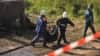 Russian rescue workers remove a body bag at the site of a deadly fire that razed a psychiatric hospital in Novgorod Oblast, killing at least 37 people.