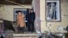 A man and woman stand outside their partially destroyed house after a drone strike on Kharkiv on the evening of May2-3. 