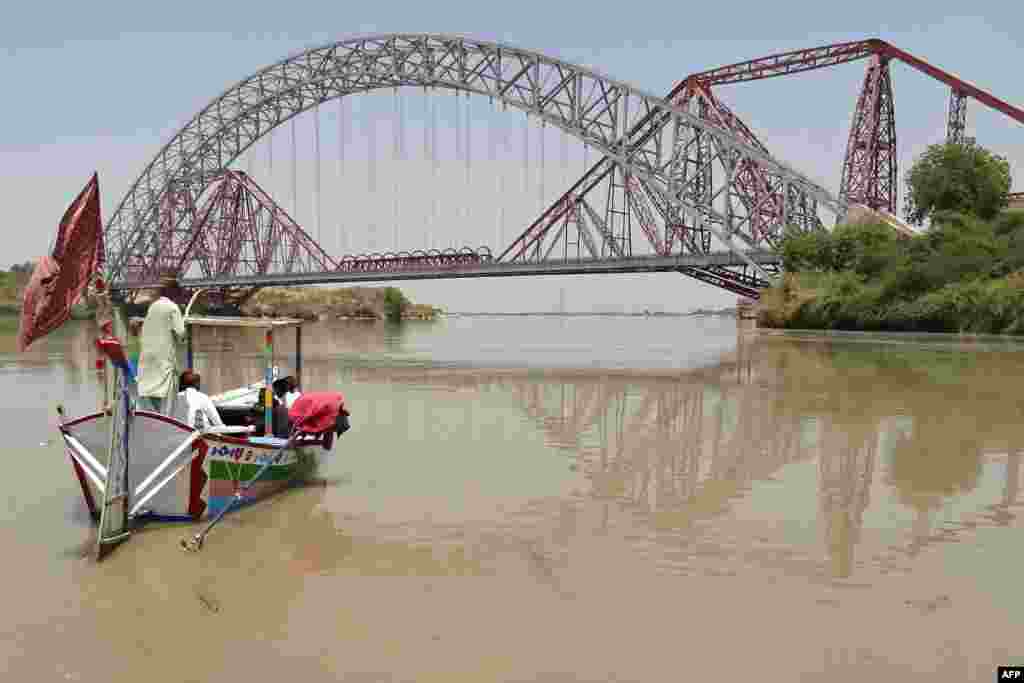 People take a boat ride in the waters of the Indus River in Pakistan's southern Sindh Province.
