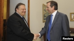 Greece's New Deomocracy party leader Antonis Samaras (right) shakes hands with the leader of the socialist Pasok party Evangelos Venizelos at the parliament in Athens.
