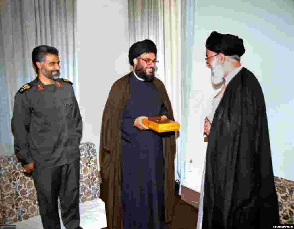 علی خامنه ای در حال اهدای قرآن به حسن نصرالله با حضور قاسم سلیمانی، ۱۳۷۹