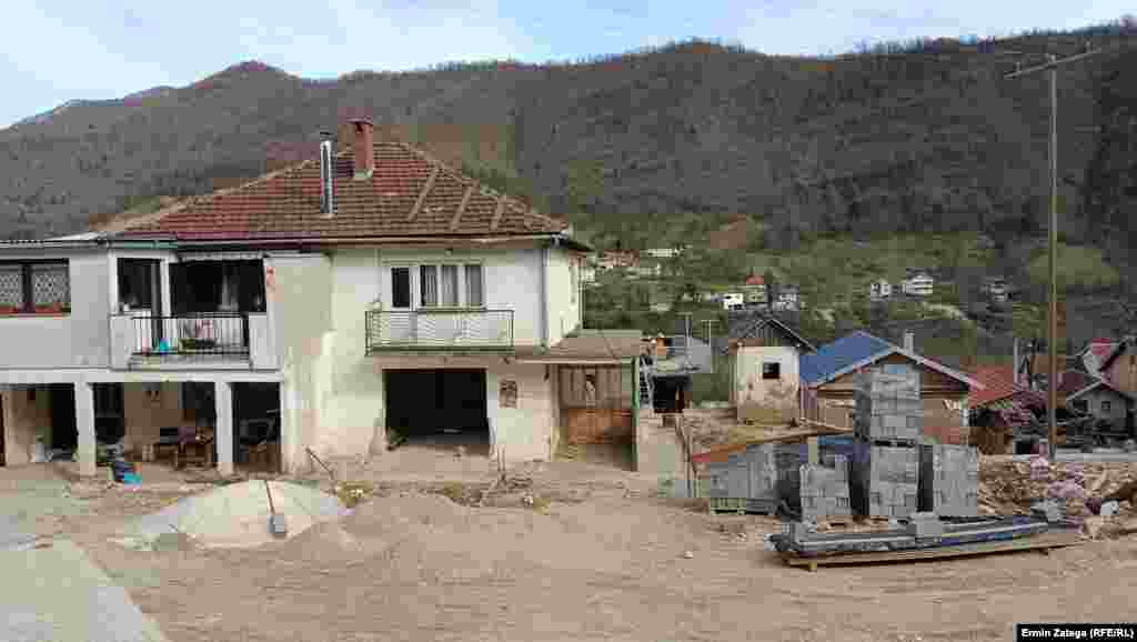 Пред некои куќи има материјал за реконструкција, песок, дрва и бетонски блокови.