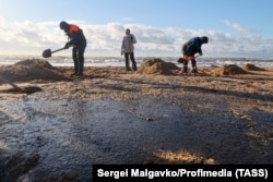 Volonteri sakupljaju pijesak natopljen mazutom na obali krasnodarskog regiona, decembar 2024.