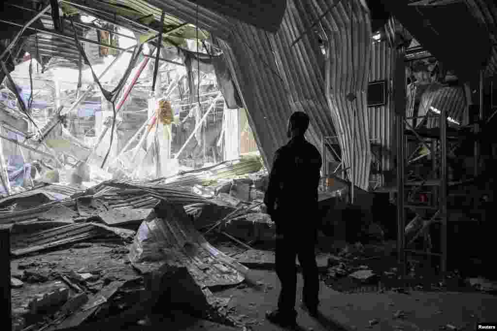 A Ukrainian police officer stands at the site of a Russian drone strike in Odesa.
