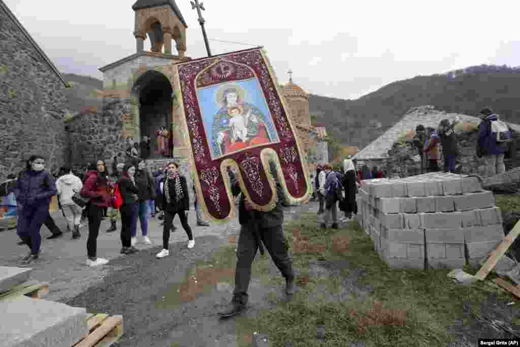 Працівник вірменської церкви виносить релігійну хоругву з монастиря Дадіванк у Шаумянівському/Кельбаджарському районі 