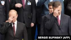Президент Росії Володимир Путін (ліворуч) і тогочасний президент України Віктор Янукович (праворуч) хрестяться під час богослужіння з нагоди відзначення 1025-річчя християнства у Київської Русі. 27 липня 2013 року
