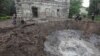 Слідчі працюють біля воронки на місці одніє із будівель у Харкові, куди прилетіла російська ракета. 27 квітня 2024 року