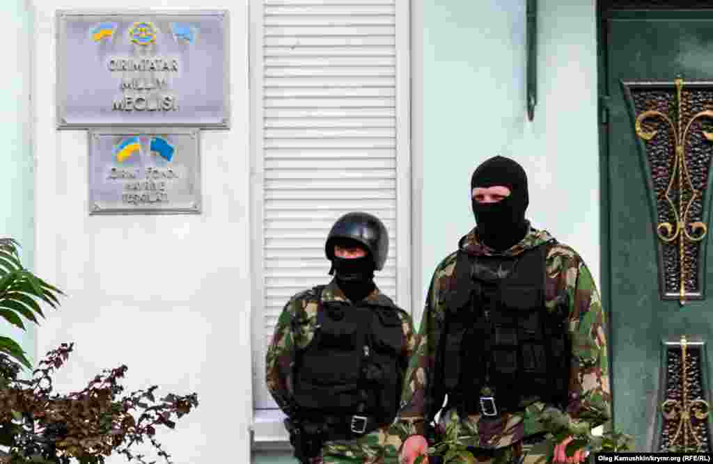 Возле входа в Меджлис стоят вооруженные автоматчики в масках. 