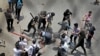 Studenti tuku policajca palicama tokom protesta u Daki, Bangladeš, 18. juli 2024. 