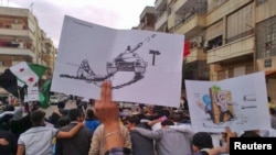 Antiregime protesters march through the streets in the Syrian city of Homs on October 30.