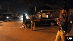 Police keep vigil at a security checkpoint in Karachi.