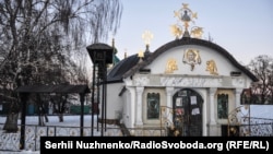 На передньому плані так звана «каплиця» УПЦ (Московського патріархату), незаконно збудована біля фундаменту Десятинної церкви на території Національного музею історії України, лютий 2018 року