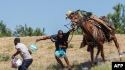 Na ovoj fotografiji, agent američke Pogranične službe na konju pokušava spriječiti migranta iz Haitija da uđe u kamp na obali Rio Grande u blizini Međunarodnog mosta Acuna Del Rio u Del Riou (19. septembra 2021.)