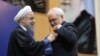 Iranian President Hassan Rohani (left) presents Foreign Minister Mohammad Javad Zarif with a Medal of Honor for his role in the implementation of a nuclear deal with world powers, in Tehran on February 16. 